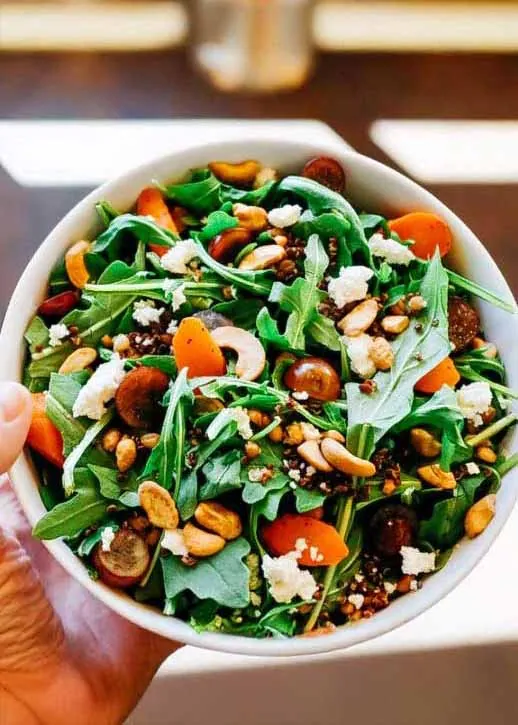 Hand holding bowl of salad in