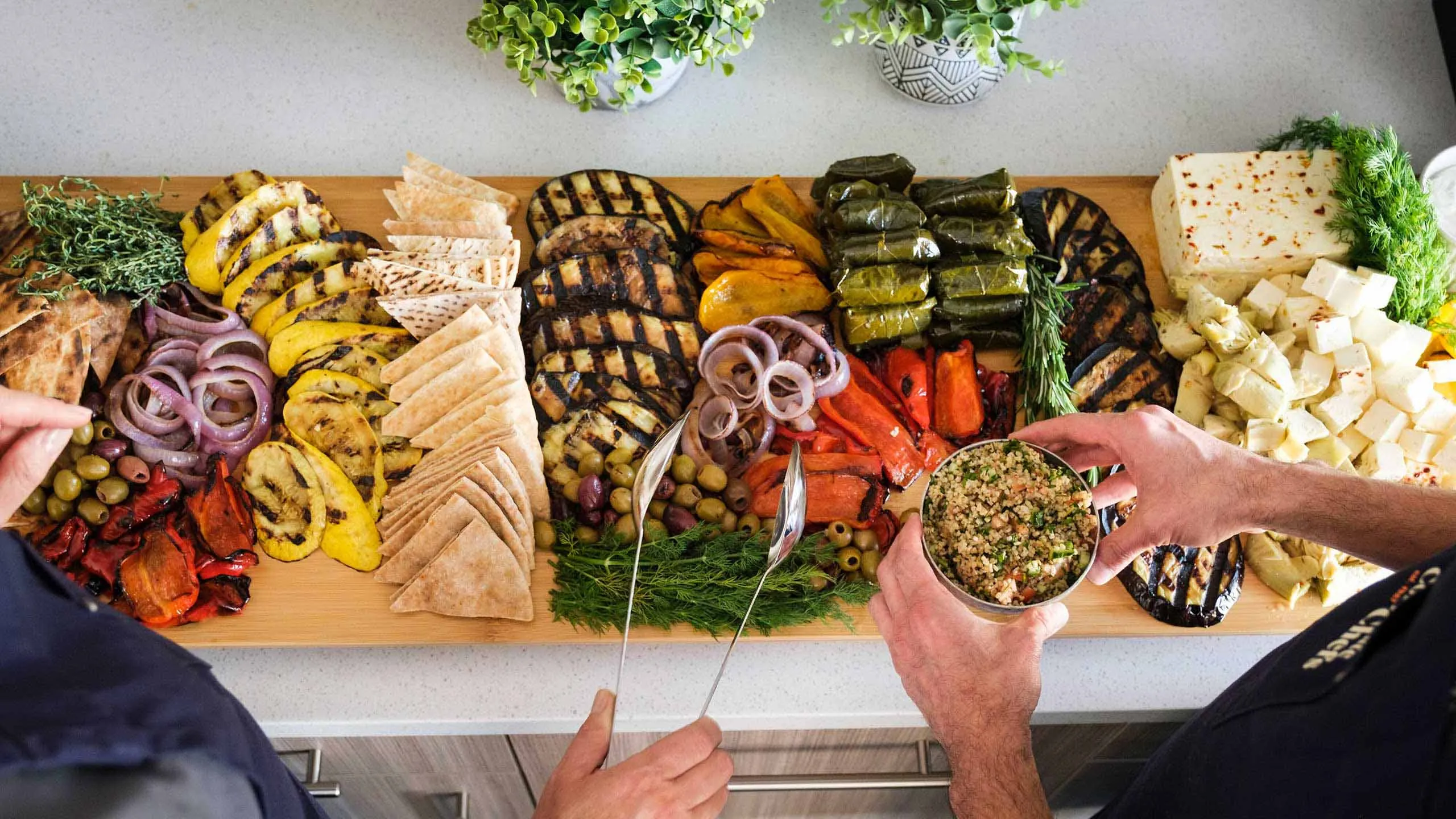 Overhead shot of grilled mezze platter with pita, hummus, olives, and vegetables